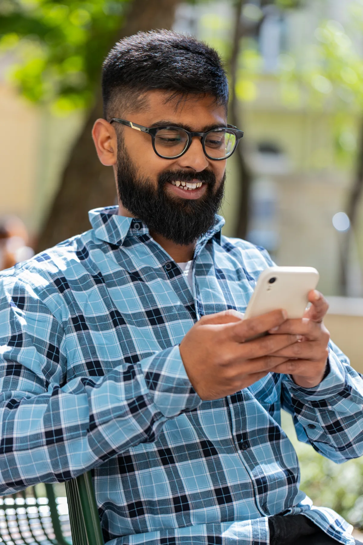 Smiling man checking his phone outdoors